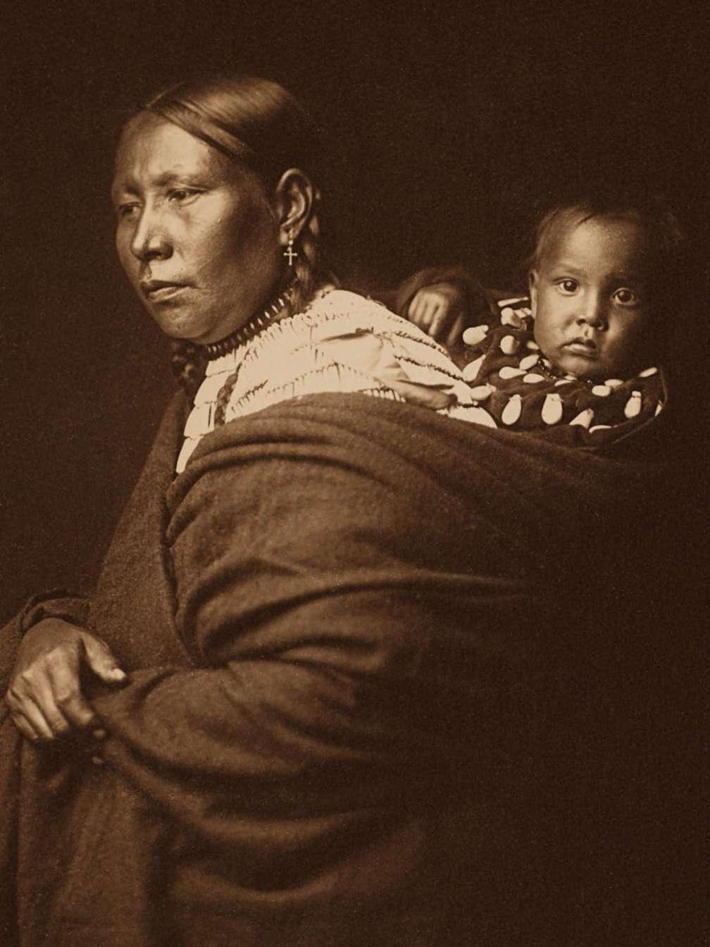This Sioux mother with a curious baby on her back posed in 1905.